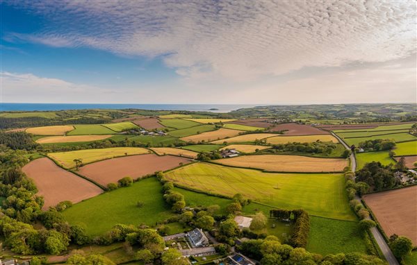 Ariel view of the farm with the sea and Looe Island beyond 